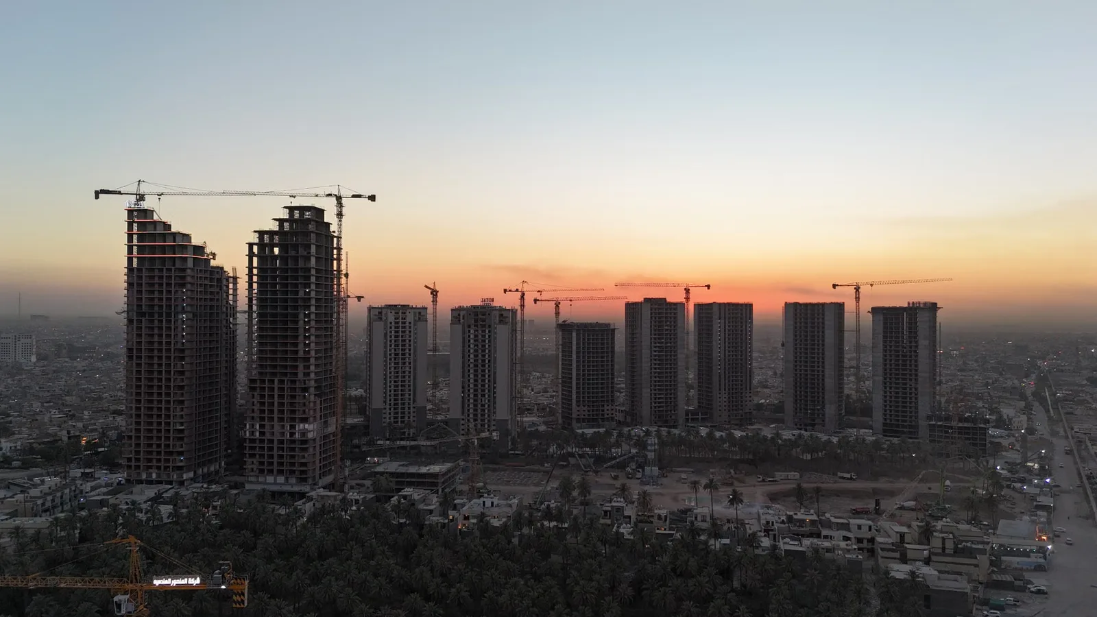 Bağdat'ta gün batımında gökdelen ve vinç siluetleri